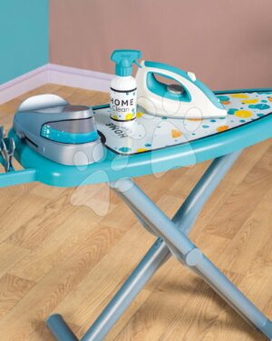 Enfant jouant avec une planche à repasser enfant turquoise avec fer à vapeur jouet, cintres et pinces à linge – jeu role-play éducatif dès 3 ans